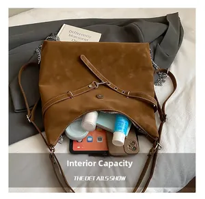 Detail view of internal capacity showing brown suede tote bag with tablet and daily items