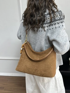 Braune Hobo-Tasche aus Wildleder mit Goldbeschlägen und Perlenanhänger für Damen im Herbst