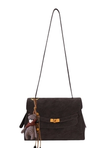Vintage dark brown crossbody bag with gold buckle and bear charm in front view
