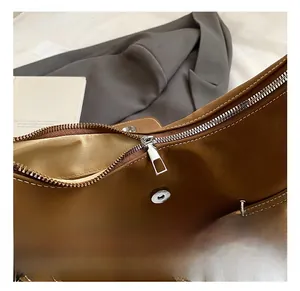 Detail view of premium brown leather texture with high-quality silver metal hardware
