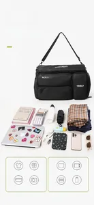 Flat lay of black nylon travel bag with multiple pockets showing large storage capacity