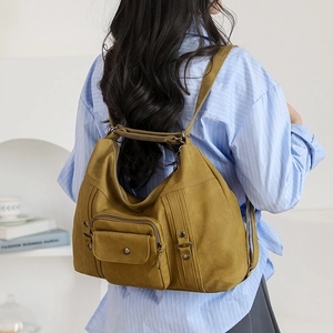 Detail view of mustard yellow vintage-style shoulder bag on a model in a casual setting