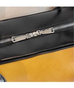 Vue macro de fermetures éclair en métal argenté lisse sur un sac cabas bicolore