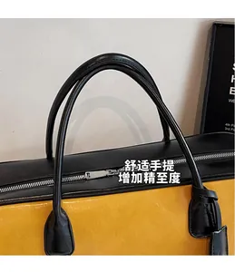 Détail du sac cabas jaune en cuir avec poignées noires contrastées et fermeture argentée