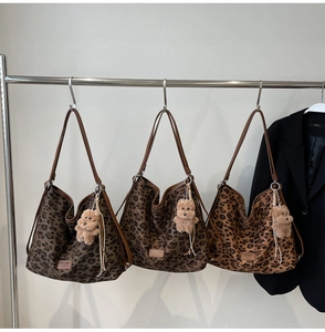 Detailed view of leopard print tote bags with brown straps and cute bear charms