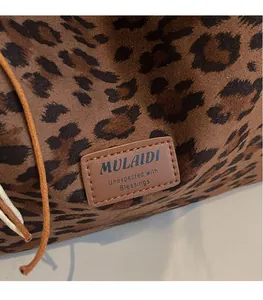 Close-up of leather label on leopard print tote bag with soft suede texture