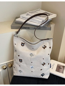 Off-white canvas tote bag with detailed cat embroidery and brown leather straps