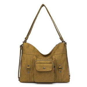 Detail of premium khaki canvas shoulder bag featuring utility pockets and metal D-ring buckle