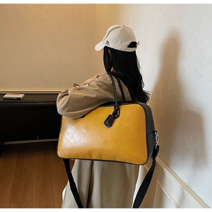 Détail du grand sac cabas jaune avec bandoulières noires porté par un mannequin