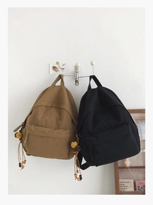 Detail of canvas backpack front zipper pocket and bohemian charm with tassels