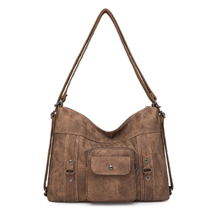 Detailed view of brown retro hobo bag with flap pocket, metal rings, and matte texture