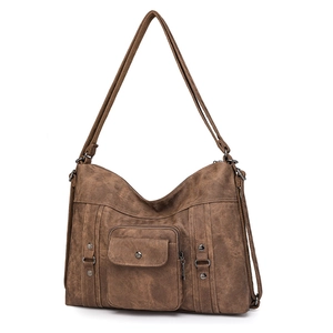 Detail of vintage brown shoulder bag showing retro texture and metal rivet accents