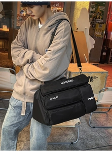 Detail of waterproof nylon travel bag featuring three zippered pockets and white typography