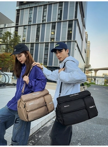 Outdoor street style shot showing large black and khaki multi-pocket travel messenger bags