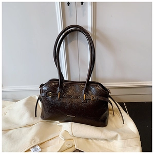 Detail of dark brown tote bag with oily leather texture and metal buckle on white suit