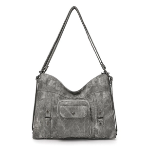 Close-up of retro gray washed canvas tote bag with rivets and multi-pocket details