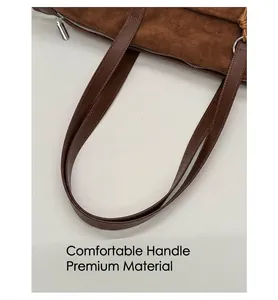 Detail of reinforced leather handle with stitching on brown frosted suede bag