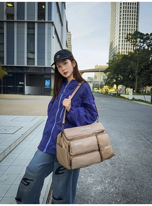 Detail view of khaki multi-pocket travel bag with functional utility design and sturdy straps