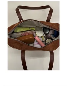 Macro view of brown suede handbag interior showing large storage capacity for daily essentials