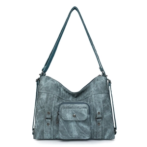 Detailed view of the vintage washed blue shoulder bag featuring a front pocket and rivets