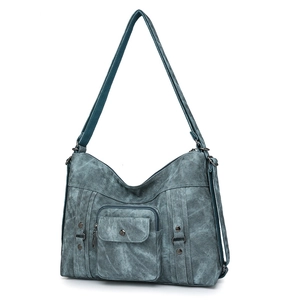 Detailed macro of vintage teal canvas bag with rivets, flap pocket and D-ring hardware