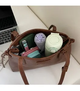 Spacious interior of brown tote bag showing capacity for water bottle and umbrella
