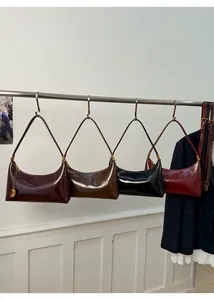 Selection of retro baguette bags in wine red, dark brown, and black hanging on display