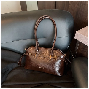 Detail of dark brown wax leather tote with vintage texture and golden metal buckle