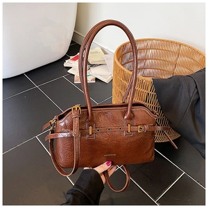 Close-up of vintage brown oil-wax leather tote with buckle belts and metal eyelets