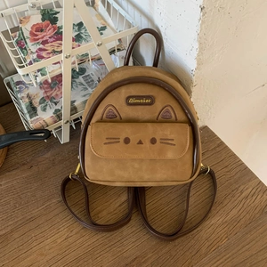 Close-up of suede mini backpack featuring cute embroidered cat ears and whiskers