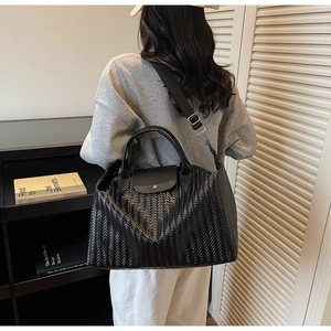 Gros plan du grand sac cabas en cuir PU tressé noir avec fermeture à bouton argenté