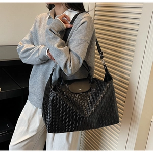 Détail du tissage noir sur un grand sac de voyage avec rabat et bandoulière réglable