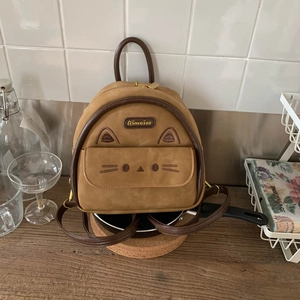 Close-up of khaki faux suede backpack featuring cute cat ears and embroidered face details