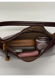 Detail view of burgundy leather shoulder bag showing spacious interior with pockets