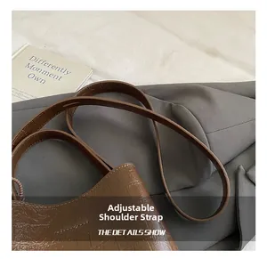 Close-up of adjustable strap and brown stone pattern texture on bucket bag