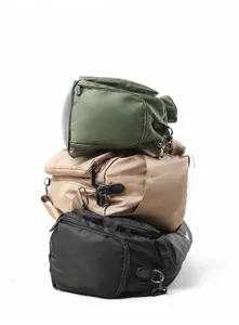 Vertical stack of multi-functional travel bags in olive, khaki, and black nylon
