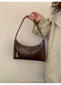 Detail of the vintage dark brown leather underarm bag with gold hardware and logo