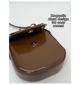 Detail of magnetic snap closure on vintage brown saddle bag with smooth leather finish