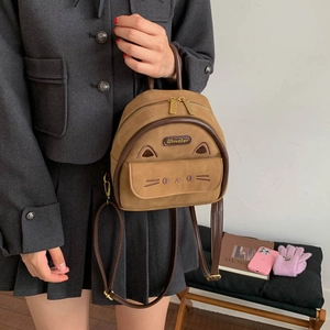 Detail of suede vintage backpack with cute cat ears and embroidered cat face details
