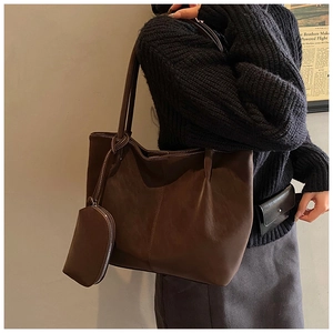 Detail of dark brown tote bag with matching zipper pouch accessory and long shoulder straps