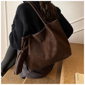 Detail view of large chocolate brown leather tote bag with matching zipper pouch