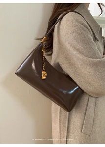 Detail of Hinaire dark coffee baguette bag with gold chain and FASHION pendant charm