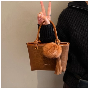Détail du sac seau léopard avec pompon en fourrure et breloque à franges