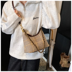 Detail showing vintage plaid semi-circle bag with golden chain and brown leather strap
