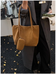 Detailed view of brown matte tote bag with small zip pouch and decorative stitching