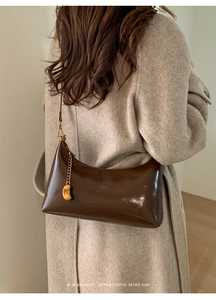 Detail of dark brown leather shoulder bag with gold chain and HIHATE embossed logo