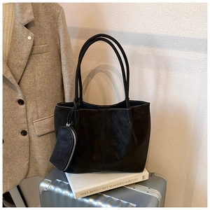 Detail of black matte tote bag with matching pouch on silver suitcase for commuting