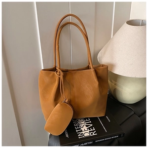 Detail view of brown matte leather tote bag with a matching small coin purse pendant