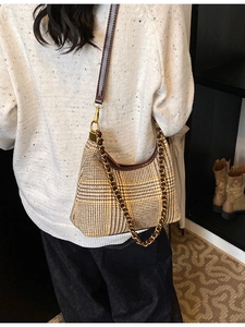 Houndstooth hobo bag with brown leather strap and gold chain detail on model