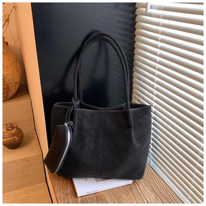 Detail of black leather tote bag with white contrast stitching and matching coin purse
